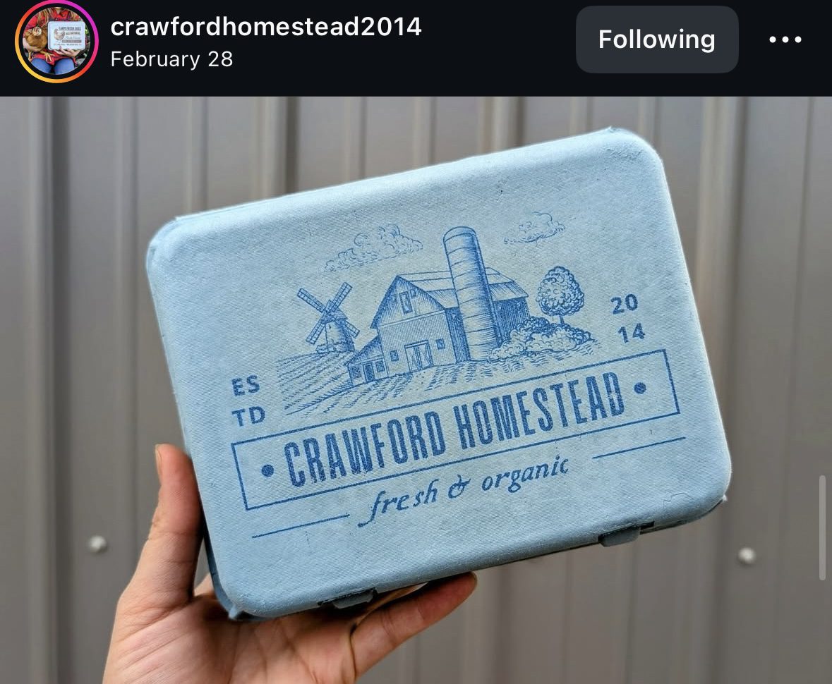 Hand holding blue Crawford Homestead carton.