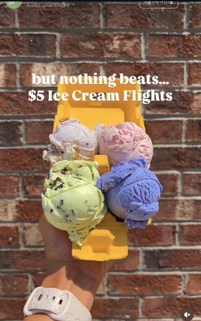 Hand holding colorful ice cream flight cones.