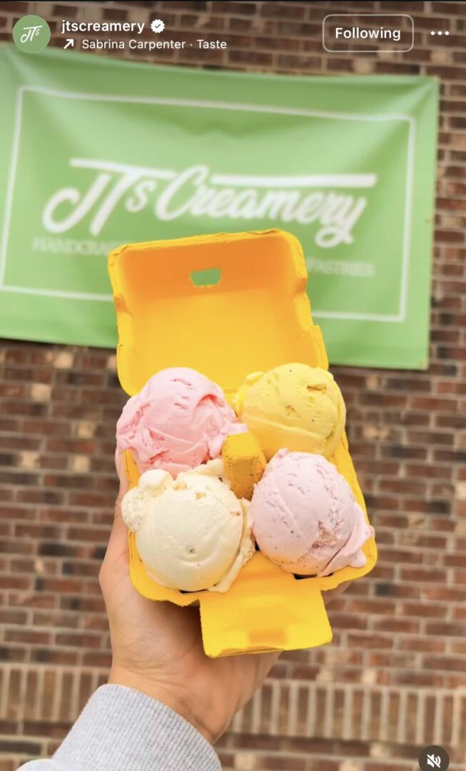 Hand holding four scoops of colorful ice cream.